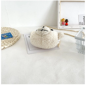 Détail du sac bandoulière en peluche laine d'agneau blanche avec sangle tissée douce