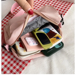 Detailed interior view of a pink canvas crossbody bag showing spacious main compartment
