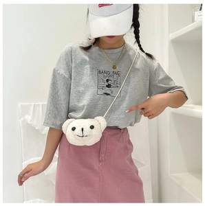 Sac à bandoulière en peluche ours blanc porté par un mannequin en intérieur