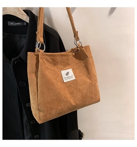 Detailed view of brown corduroy tote bag showing fabric texture and metal ring buckle