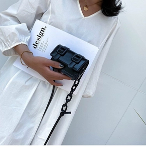 Minimalist black mini square crossbody bag with chunky chain strap and double buckle