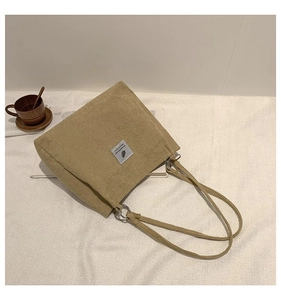 Detail of khaki corduroy tote bag showing ribbed texture and stylish fabric label