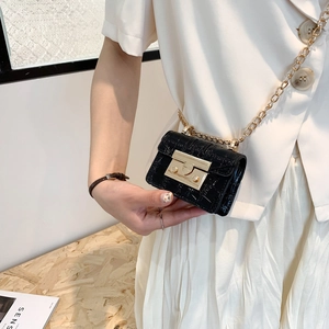 Mini black crocodile embossed crossbody bag with gold chain strap shown on model