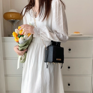 Minimalist black cube chain crossbody bag with pebble leather and drawstring closure
