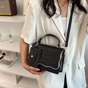 Elegant black crocodile pattern handbag with crossbody strap and golden hardware