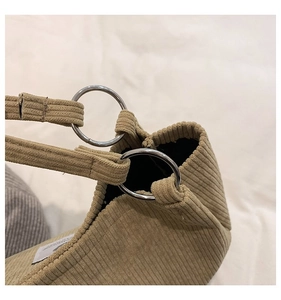Detail of corduroy tote bag showing silver metal ring connector and ribbed fabric texture