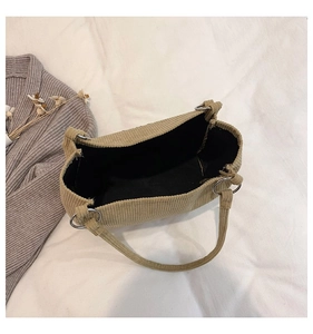 Macro shot of khaki corduroy tote with silver rings and spacious black interior lining