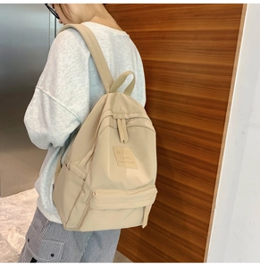 Seitenansicht des beigen Nylon-Rucksacks mit mehreren Reißverschlussfächern und viel Platz