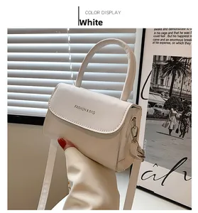 Detail of white faux leather mini bag featuring gold clasp and Fashion & Bag logo