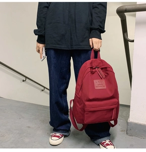 Detail eines burgunderroten Oxford-Rucksacks mit MRMI Leisure Logo und Front-Reißverschluss