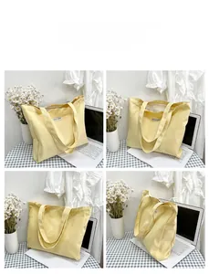 Detail view of a yellow canvas tote bag with wide straps in a lifestyle setting
