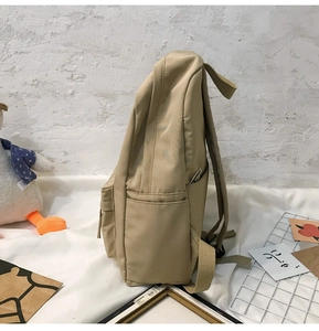 Detailansicht des beigen Rucksacks mit funktionalen Seitentaschen und verstärkten Gurten