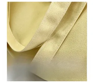 Close-up of durable reinforced stitching on yellow canvas tote bag handle detail