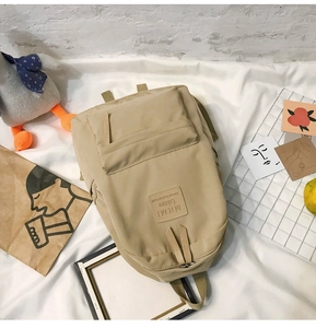 Detailaufnahme des khakifarbenen Nylon-Rucksacks mit MRMI Leisure Leder-Logo-Patch