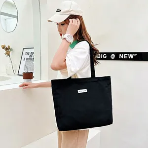 Minimalist black canvas tote bag with large capacity and shoulder strap for daily shopping