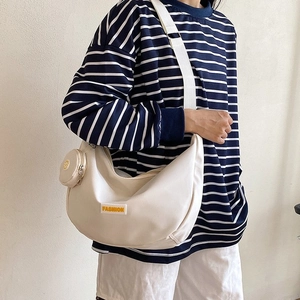 Cream white crescent crossbody bag with yellow FASHION label and small round coin purse