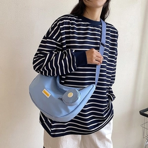 Light blue crescent hobo crossbody bag with detachable round coin purse on a model