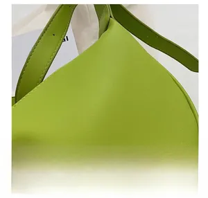 Close-up of fluorescent green leather bag showing fine lychee grain and precise stitching