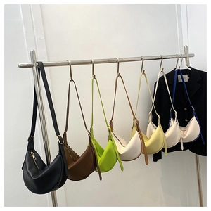 Minimalist half-moon hobo shoulder bags in various colors on display stands