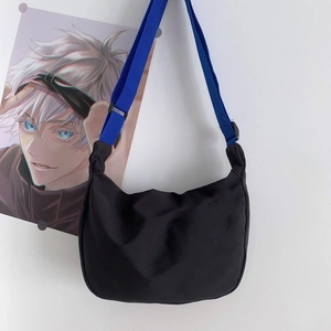 Detail of adjustable royal blue nylon strap and black buckle on minimalist crossbody bag