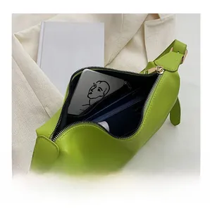 Detail show of crescent green crossbody bag with zipper and spacious interior storage