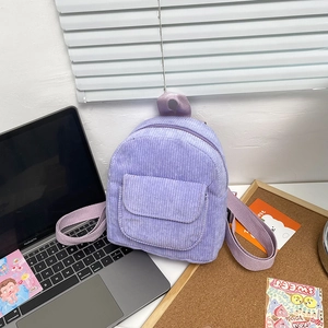Detail of lilac corduroy mini backpack showing front flap pocket and textured fabric finish