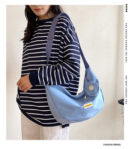 Detail of light blue hobo crossbody bag with adjustable strap and mini round coin purse