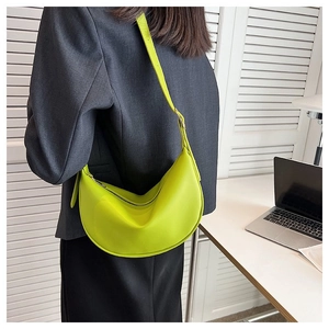 Close-up of neon green leather half-moon underarm bag with zipper and adjustable strap