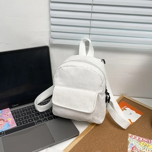 Detail of white corduroy mini backpack with silver metal zippers and front flap pocket