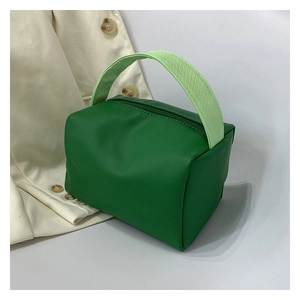 Detail of green cube storage bag showing smooth texture and woven handle design