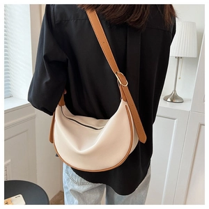 Detailed back view of a minimalist cream and brown leather crescent crossbody bag