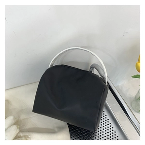 Detail of black semi-circular crossbody bag with silver handle and nylon texture