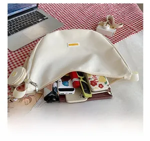 Large capacity crescent nylon crossbody bag showing spacious interior with extra coin pouch
