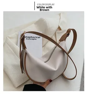 Detail of half-moon shoulder bag in white and coffee PU leather with adjustable strap