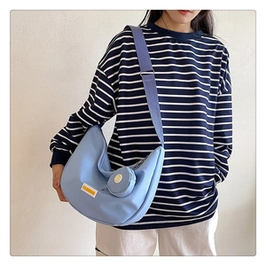 Light blue crescent canvas crossbody bag with small matching round pouch and fashion label