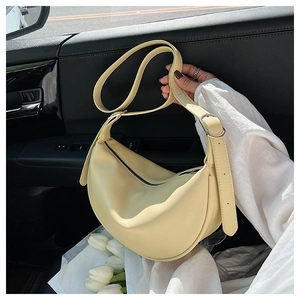 Close-up of yellow crescent hobo bag with adjustable strap and silver hardware buckle