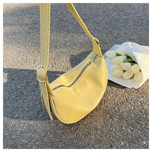 Detail of adjustable metal buckle on yellow faux leather crescent shoulder bag