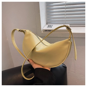Detail of a bright yellow half-moon hobo bag with adjustable strap and silver hardware