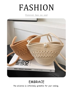 Detail of hand-woven straw bucket bag with elegant pearl closure and wave texture
