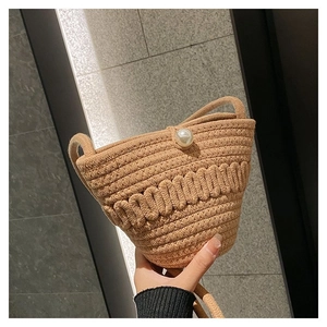Detailed close-up of woven rope bucket bag with elegant pearl clasp and chic natural texture