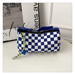 Détail du sac à bandoulière cylindrique à damier bleu avec sangle et pendentif en cœur