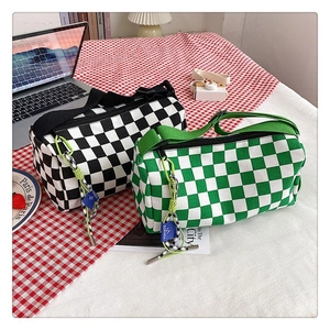 Makroaufnahme der modischen Canvas-Zylindertaschen mit Karomuster in Schwarz und Grün
