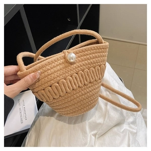Close-up of woven bucket bag featuring large pearl button and natural khaki texture