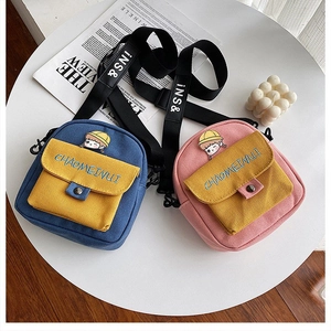 Detalle de bolsos bandolera de lona de colores con bordado de dibujos y correas ajustables