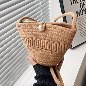 Mini straw bucket bag with wave weave texture and pearl closure for summer beach fashion