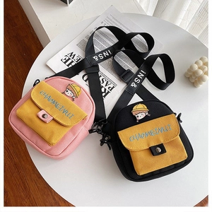 Detalle de mini bolsos de lona con bordado de niña y correas ajustables