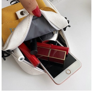 Detalle del bolso bandolera de lona que muestra la capacidad de almacenamiento interno