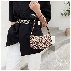 Detailed view of a leopard print crescent shoulder bag worn with a black blazer