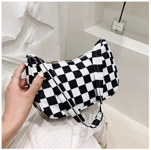 Detail of black and white checkerboard canvas hobo bag with zipper and strap