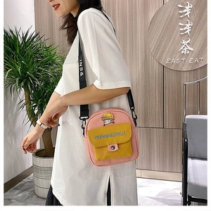 Detalle del mini bolso bandolera de lona rosa y amarillo con motivo de niña de dibujos